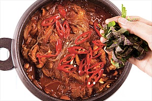 ⑤의 뚝배기에 홍고추를 넣고 뚜껑을 연 채 1분간 끓인 후 깻잎을 올린다.